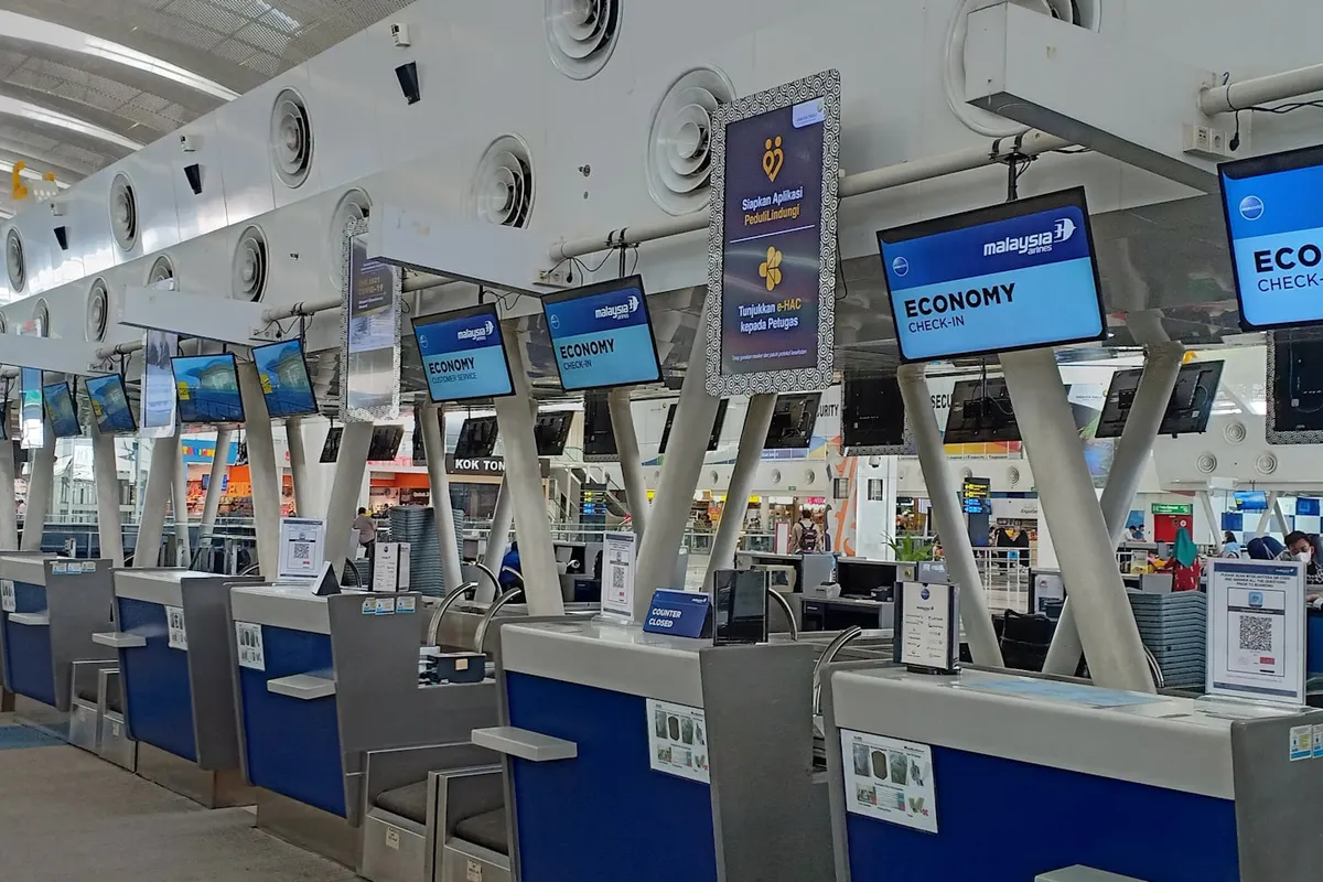 A row of airline economy check-in counters at an airport terminal
