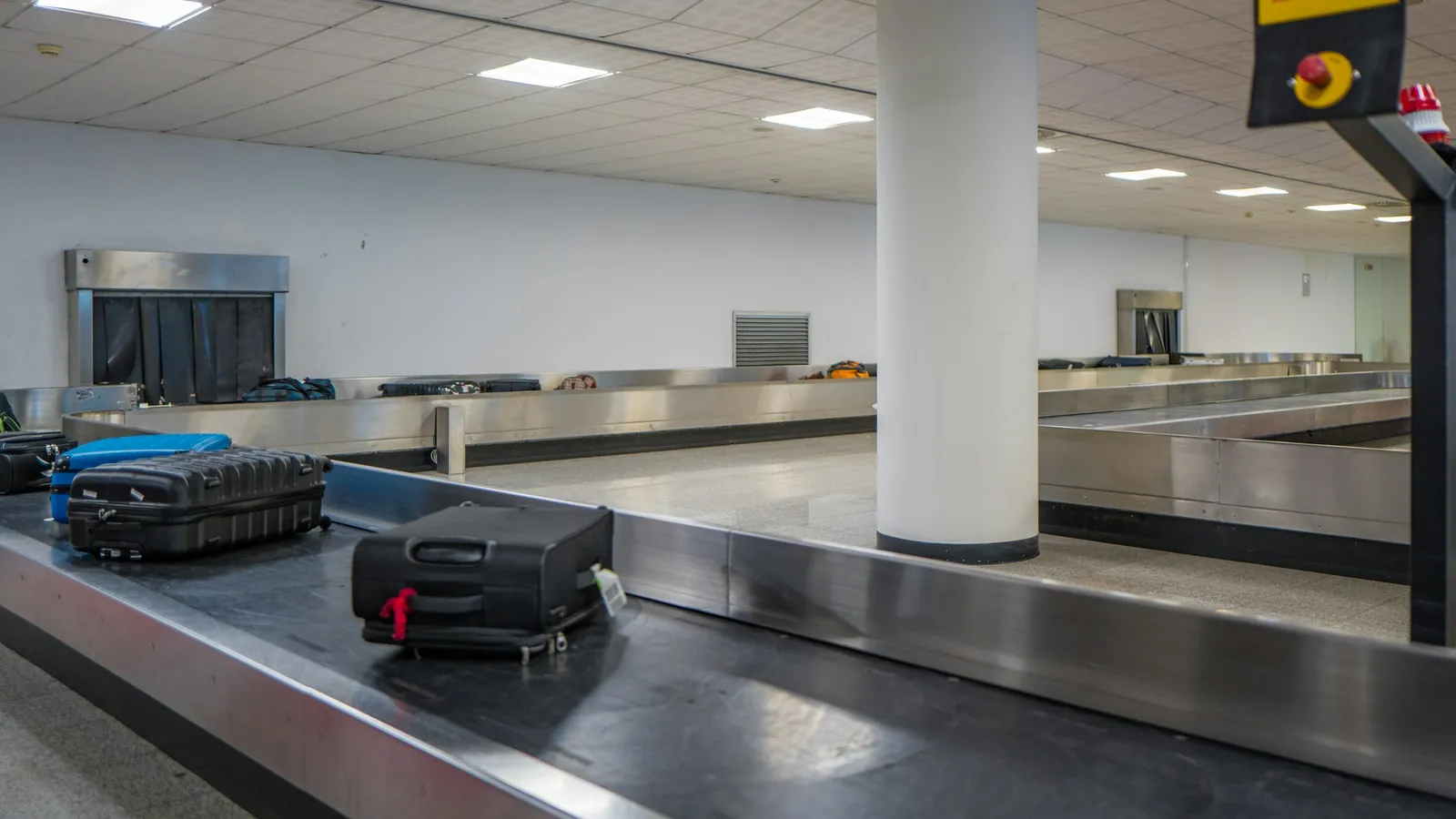 Suitcases moving along a conveyor belt at an airport baggage claim