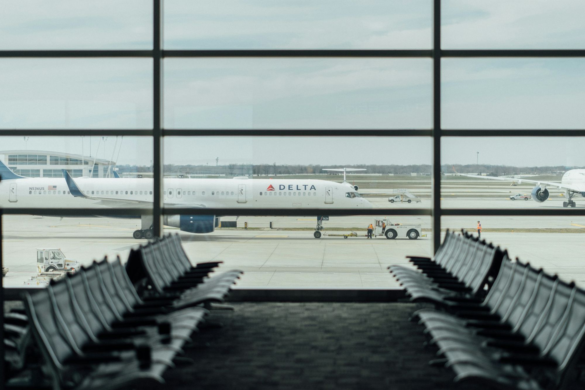 Delta Air Lines airplane seen from an empty airport gate waiting area