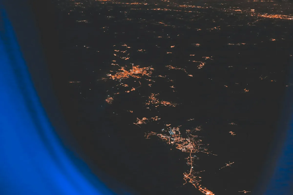 A view of city lights at night through an airplane window